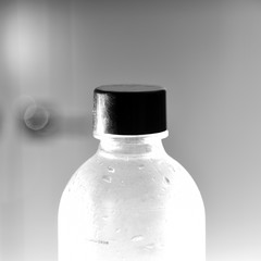Clear plastic water bottle with black cap closeup