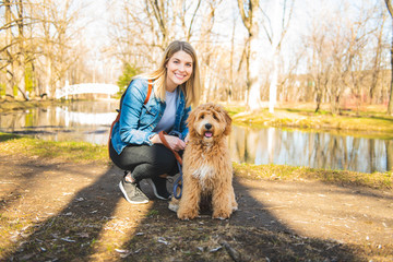 Happy Labradoodle Dog and woman outside at the park