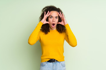 Dominican woman over isolated green background with surprise expression