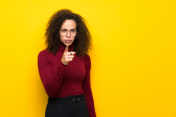 Dominican woman with turtleneck sweater frustrated and pointing to the front