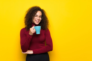 Dominican woman with turtleneck sweater holding a hot cup of coffee