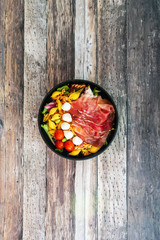 Salad made with cooked pasta, mixed green salads, cherry tomatoes, Mozzarella cheese and smoked ham served with accompaniment