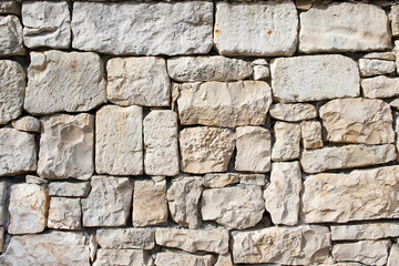 Stone natural wall of different blocks. The texture of the stone lined with blocks of natural stone.