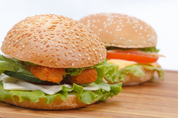 hamburger with fish cutlets cheese and fresh herbs on the background of cheeseburger