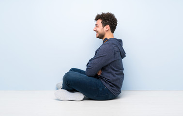 Young man sitting on the floor in lateral position