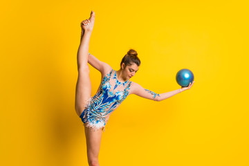 Girl doing rhythmic gymnastics with ball .