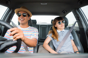 Front view of Funny moment couple asian man and woman sitting in car. Enjoying travel concept.