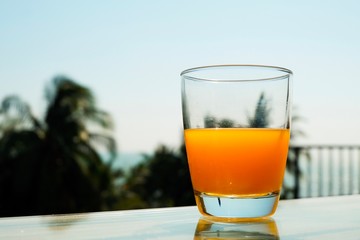 A glass of orange juice on the sea background