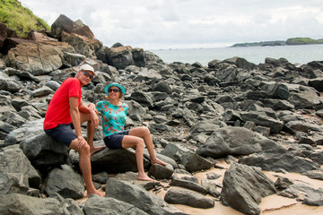 Fototapeta premium Mature Couple Sitting at a Rocky Beach Enjoying Each Other