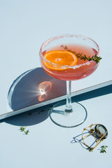 Grapefruit and thyme cocktails, refreshing drinks with ice on a light blue background. Summer...