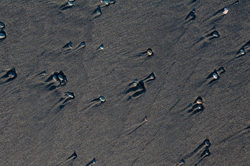 Black volcanic sand waves abstract background texture with copyspace. Black beaches of Iceland.