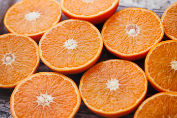 Fresh sliced oranges on wooden table. Halves of fruit.