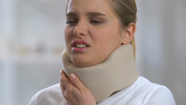 Lady in foam cervical collar suffering from strong neck pain, rehabilitation