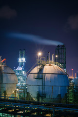 Gas storage sphere tanks in petrochemical plant with night, Products tank of petroleum industrial with smoke stacks