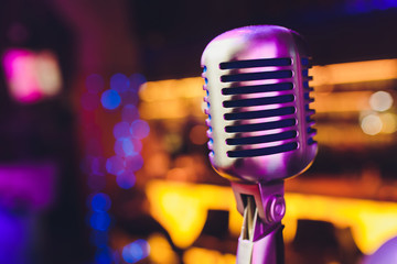 Retro microphone against blur colorful light restaurant background.