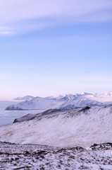 Early morning sunrise in Tazheran steppes. Snow-covered hills are colored in shades of ultra-violet. Photo toned.