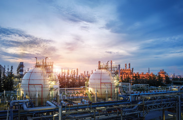 Gas storage sphere tanks and pipeline in oil and gas refinery industrial plant on sky sunset background