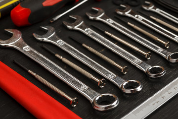 Fototapeta premium Set of different wrenches with other tools on black background