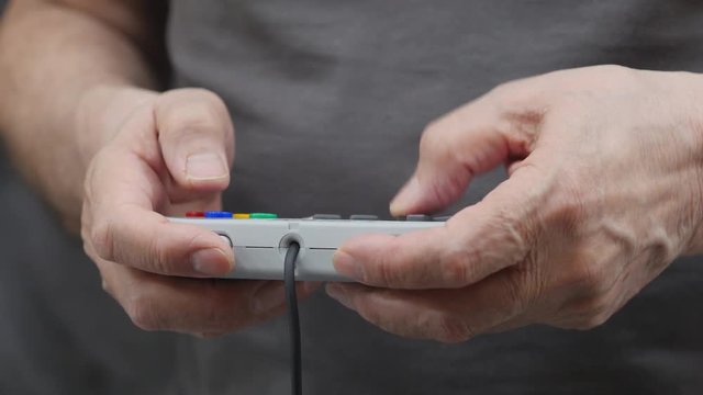 An Elderly Man Playing Video Game On Controller .