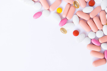 many pills and drugs in bright colors on white background