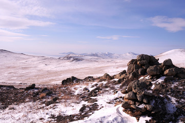 Early morning sunrise in Tazheran steppes. Snow-covered hills are colored in shades of ultra-violet. Photo toned.
