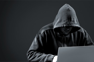 Thief in black clothes on grey background