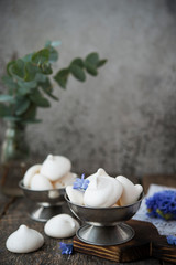 Homemade white meringue of egg whites on aged wooden table