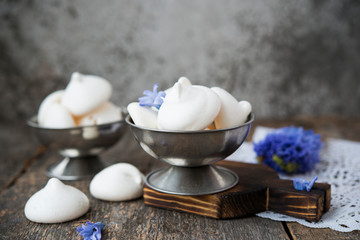 Homemade white meringue of egg whites on aged wooden table