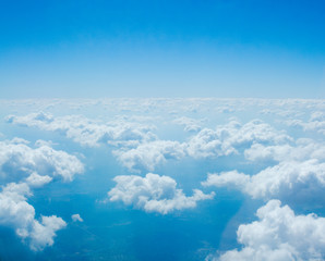  view of small white clouds to the end of the horizon, from the window of the airliner