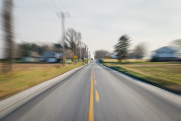 Car coming down the road, with a lot of movement and speed swooshing toward it