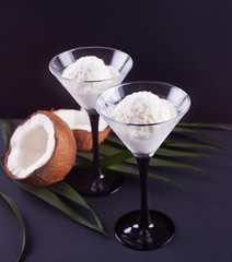 Coconut ice cream on the black background with palm leaf and coconut