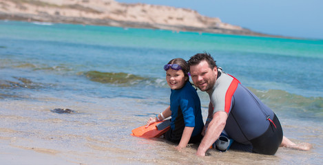 Fototapeta premium Happy child playing on the beach with dad