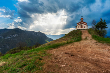 Fototapeta na wymiar Small chapel in Rhodope mountain near Borovo village, spring sunset photo from Bulgaria