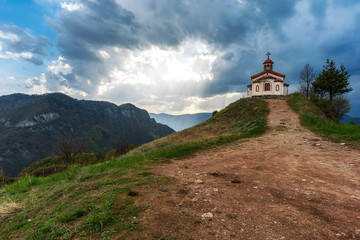 Fototapeta na wymiar Small chapel in Rhodope mountain near Borovo village, spring sunset photo from Bulgaria