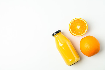 Bottle with fresh natural juice and oranges on white table, space for text. Natural drink