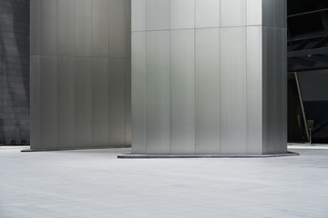 Empty ground in front of modern steel wall buildings .