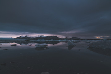 Jokulsarlon, glacier lagoon in Iceland at night with ice floating in water. Cold arctic nature landscape scenery. Ice melting.