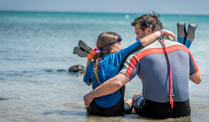 Szczęśliwe dziecko spędza wakacje na plaży i nurkuje z tatą