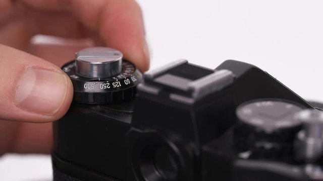 A close-up demonstration of a photographer taking pictures using vintage single-lens reflex camera. Isolated, on white background