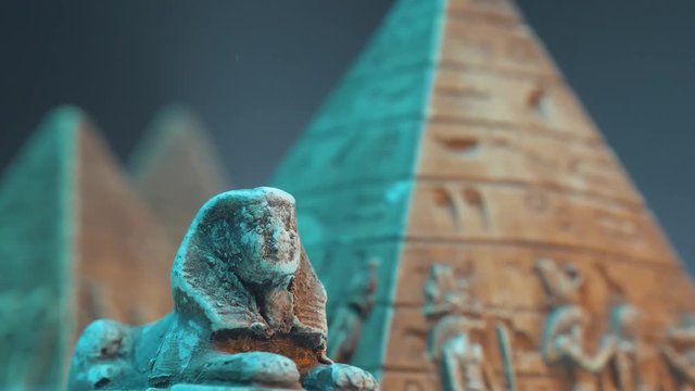 Closeup on an Egyptian sphinx with pyramids surrounding