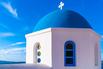 Fototapeta na wymiar Blue dome of a traditional whitewashed church in Oia against blue sky, Santorini, Greece