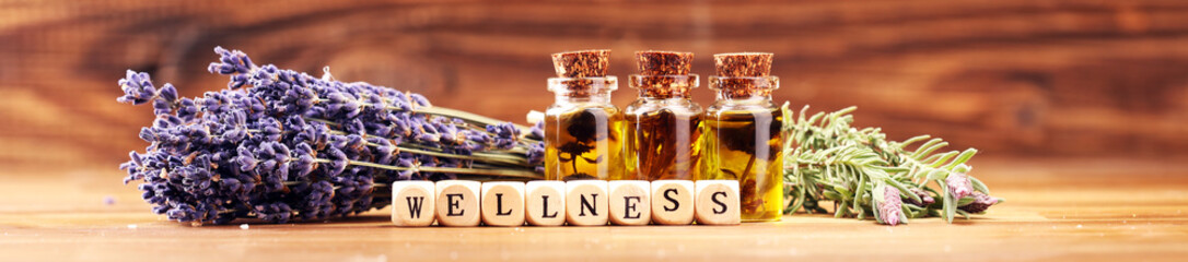 lavender oil in a glass bottle on a background of fresh flowers.