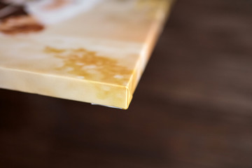 Photo canvas print. Sample of stretched photography with gallery wrapping on a wooden stretcher bar. Lateral side view, closeup. Selective focus