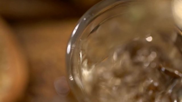 Brazilian gold cachaca pouring in glass cup. Sugar Cane Derivatives. Sugar and sugarcane on old wood background.