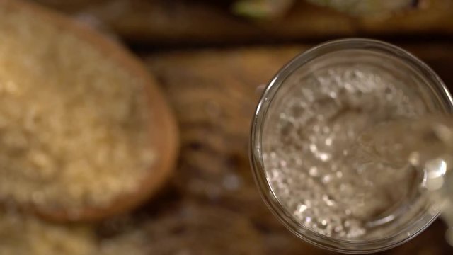 Brazilian gold cachaca pouring in glass cup. Sugar Cane Derivatives. Sugar and sugarcane on old wood background.