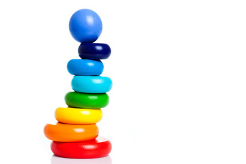 child pyramid of round shape from wooden parts of different colors isolated on white background with place for text. Copy Space multi colorful toy.