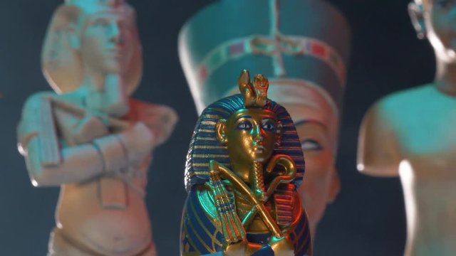 Closeup on Egyptian pharaoh figure surrounded by other relics.