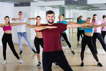 joyous men women posing in fitness studio