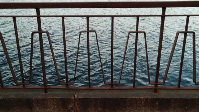 Looking through walkway railing, at the calmly flowing Daugava river