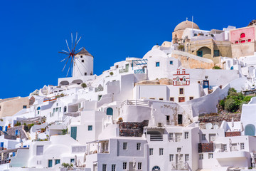 Fototapeta premium Santorini landscape with view of whitewashed buildings and windmills in Oia, Greece